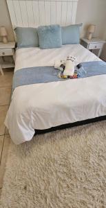 a bed with a blanket and a stuffed animal on it at 106 Barracuda Self-catering in Geneva