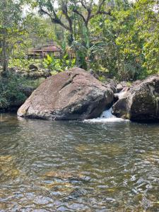 een rivier met een grote rots in het water bij Sitio e Pousada Vagalumes in Engenheiro Passos +9 foto's