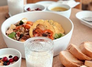 a salad in a white bowl on a table with bread at 제주 신성의 숲 웰니스 호텔 in Haean
