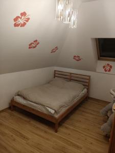 a small bed in a bedroom with a chandelier at Agroturystyka na Winnicy in Dys