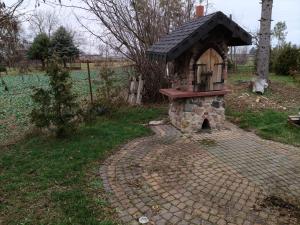 a small brick oven with a roof on a field at Agroturystyka na Winnicy in Dys +18 photos