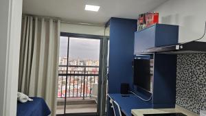 a bedroom with a blue wall with a large window at Studio | Expo Stay Tucuruvi Metro |Swimming pool in São Paulo