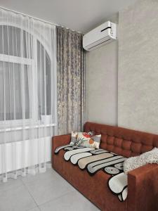 a brown couch in a room with a window at Avinion 2 Апартаменты у моря in Odesa