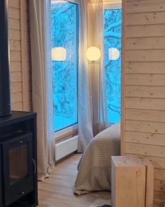 Villa Louhikko - Aavasaksa, Lapland في Aavasaksa: غرفة نوم بها سرير ونافذة كبيرة