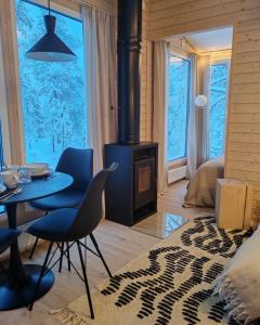 Villa Louhikko - Aavasaksa, Lapland في Aavasaksa: غرفة معيشة مع طاولة وموقد