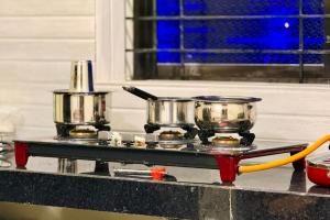 a tray with two pots and pans on a counter at Sadanand Villa in Jāmb +2 photos