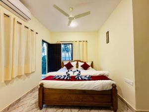 a bedroom with a bed with red and white pillows at Sadanand Villa in Jāmb