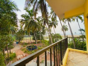 a balcony with a view of the ocean and palm trees at Sadanand Villa in Jāmb