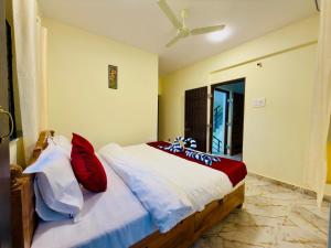 a bedroom with a bed with white and red pillows at Sadanand Villa in Jāmb