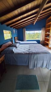 een slaapkamer met een groot bed en een raam bij Sitio e Pousada Vagalumes in Engenheiro Passos