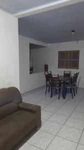 a living room with a couch and a table and chairs at Casa em Ubatuba beach two in Ubatuba