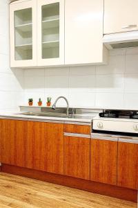 een keuken met houten kasten en een spoelbak bij new홍대 연남동 아늑한 감성숙소#최대4인#연트럴파크#짐보관#올리브영 in Seoul