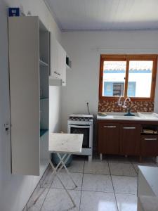 a kitchen with a stove and a sink and a window at Casa em Ubatuba beach two in Ubatuba