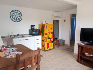 a kitchen with a table and a refrigerator in a room at Cabaña Avivando mi llama in Villa Giardino