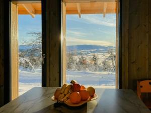 a plate of fruit on a table in front of a window at Modern Cabin By The Ski Trails At Fagerhøy in Sør-Fron