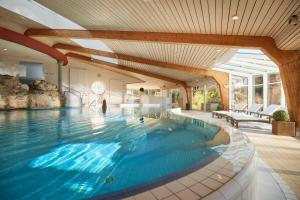 施马伦贝格佳德豪斯维泽酒店的一座带天花板的房屋内的大型游泳池