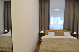 a bedroom with two beds and a mirror at Su inn apartman in Subotica