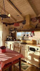una cocina con una mesa y una estufa horno superior en Tiny House Casuta Schiorului 2, Mărișel Apuseni, en Mărişel