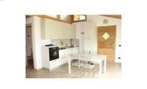 a kitchen with a white table and chairs at Rustico Prato Grande con vista lago in Carriola