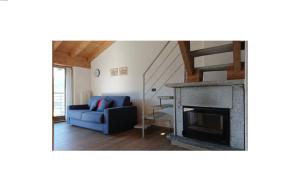 sala de estar con chimenea y sofá azul en Rustico Prato Grande con vista lago, en Carriola