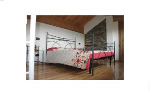 a bedroom with a bed with a red and white comforter at Rustico Prato Grande con vista lago in Carriola +4 photos