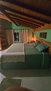 een slaapkamer met een groot bed in een kamer bij Sitio e Pousada Vagalumes in Engenheiro Passos