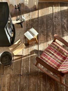 Una silla sobre un suelo de madera junto a un televisor. en Tiny House Casuta Schiorului 2, Mărișel Apuseni, en Mărişel