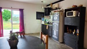 a kitchen with a table and a refrigerator at Plumas verde, casa campo in Médano de Oro +6 photos