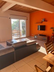 un soggiorno con un divano e una TV di Villa en face de pain de sucre 