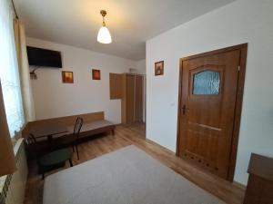 科尔别卢夫Dom w Górach Agro Zibi z zewnętrzną banią z jacuzzi的客厅设有木门和桌子