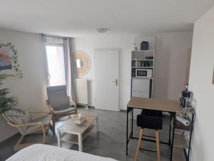 a living room with a table and chairs at Grande chambre et salle de bain privée et balcon in Strasbourg