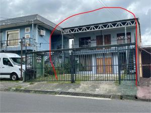 a house with a red hose attached to a fence at Big Sloth Apartment in Fortuna