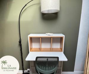 un bureau avec une lampe et une chaise dans une pièce dans l'établissement La Balinaise, aux Mathes