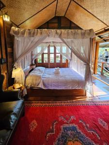 - une chambre avec un lit à baldaquin et un tapis rouge dans l'établissement Camelliana Horizon Pongyang, à Mae Rim 101 autres photos