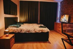 a bedroom with a bed and a brick wall at Apartament Hallera in Chełmno