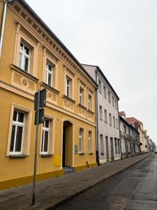 a yellow building on the side of a street at Apartament Hallera in Chełmno