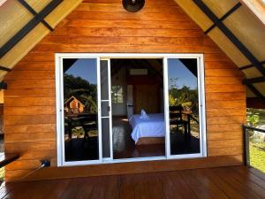 a room with sliding glass doors in a wooden house at Phayam Paradise Resort in Ko Phayam