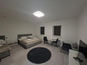 a bedroom with two beds and a table and chairs at Pansion Kod Brajlovica in Tuzla