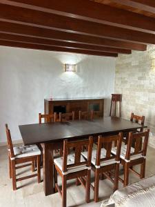 een eetkamer met een grote houten tafel en stoelen bij Ohana Villa Paula in Huertas del Palmar