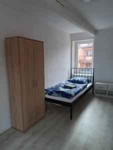 Apartmány MARTIN SARVAŠ 4 في تاخوف: غرفة نوم مع سرير وخزانة خشبية