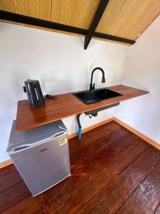 a kitchen with a sink and a refrigerator at Phayam Paradise Resort in Ko Phayam