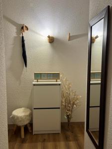 Studio près du lac في ماليبونسون: غرفة ملابس مزودة بمرآة ومظلة