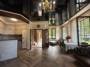 a kitchen and dining room with a table and a chandelier at Villa Kolkhi in Kvariati