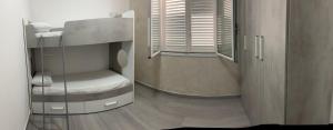 a small room with a bunk bed and a window at BALISTRERI HOUSe in Trabia +1 photo