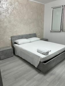 a bedroom with a large bed with white sheets at BALISTRERI HOUSe in Trabia