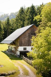 Un granero de madera grande en medio de un campo. en Hotel Garni Pension zur Wacht, en Strobl