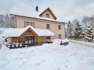 科尔别卢夫Dom w Górach Agro Zibi z zewnętrzną banią z jacuzzi的前面的地面上积雪的房子