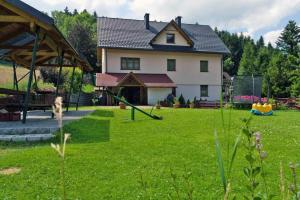 科尔别卢夫Dom w Górach Agro Zibi z zewnętrzną banią z jacuzzi的一座大房子,有一个草地庭院