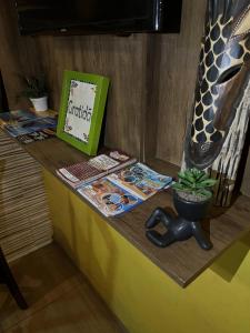 a table with a book and a potted plant on it at Pousada Sol de Iracema Praia in Fortaleza