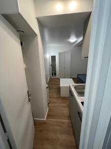a hallway leading to a room with a kitchen at Le petit Rouennais in Rouen